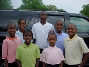 Courtesy of Victor Sims Sims (left), his biological sister, Victoria (behind him) and five foster siblings were adopted by Ronald and Violet Sims of Winter Haven.